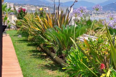 Double lavabo moderne avec robinets chromés, distributeur de savon mural et grand miroir éclairé en arrière-plan.