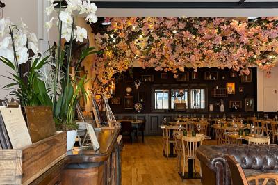 Dessert raffiné présenté dans un bol noir, décoré de fruits rouges, de crème blanche et de touches végétales.