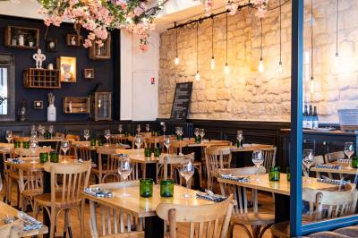 Dessert raffiné présenté dans un bol noir, décoré de fruits rouges, de crème blanche et de touches végétales.