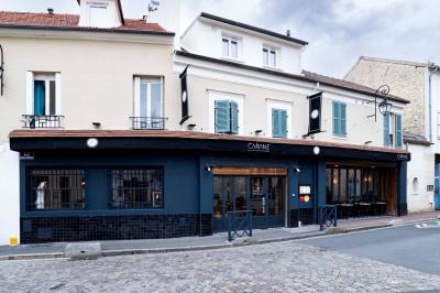 Dessert raffiné présenté dans un bol noir, décoré de fruits rouges, de crème blanche et de touches végétales.