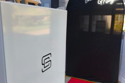 Des personnes dansent et discutent dans une salle éclairée par des lumières colorées lors d'un événement festif.