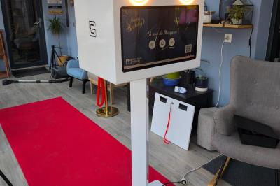 Des personnes dansent et discutent dans une salle éclairée par des lumières colorées lors d'un événement festif.