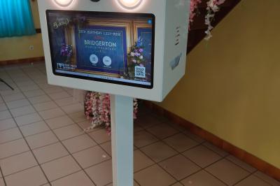 Des personnes dansent et discutent dans une salle éclairée par des lumières colorées lors d'un événement festif.