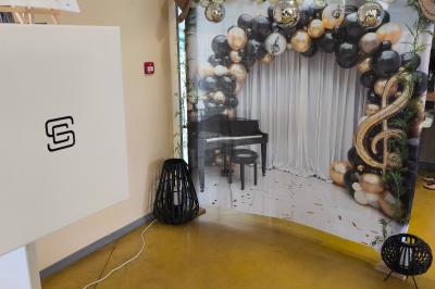 Des personnes dansent et discutent dans une salle éclairée par des lumières colorées lors d'un événement festif.