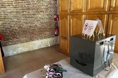 Des personnes dansent et discutent dans une salle éclairée par des lumières colorées lors d'un événement festif.