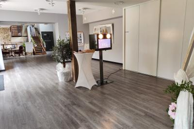 Des personnes dansent et discutent dans une salle éclairée par des lumières colorées lors d'un événement festif.