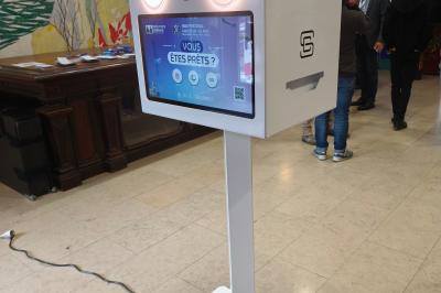 Borne photo interactive dans un espace intérieur lumineux, avec affichage d'un événement ’Spring Night Gala 2025’.