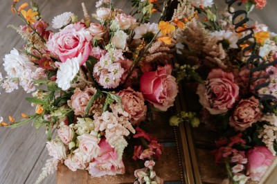 Table décorée avec des fleurs colorées, des fruits et des couverts disposés pour un repas festif.