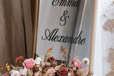 Table décorée avec des fleurs colorées, des fruits et des couverts disposés pour un repas festif.