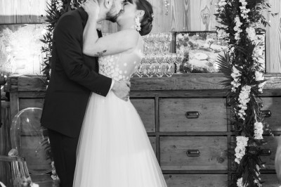 Chambre spacieuse sous combles avec poutres apparentes, lit double, coin salon coloré et grande baie vitrée.