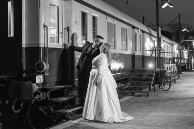 Chambre spacieuse sous combles avec poutres apparentes, lit double, coin salon coloré et grande baie vitrée.