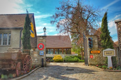Un chef pâtissier en toque décore une tarte meringuée à l'extérieur, près d'un batteur sur socle.