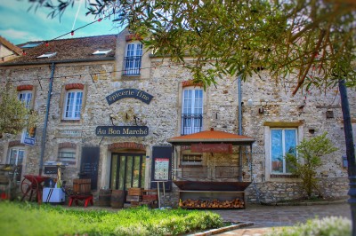 Un chef pâtissier en toque décore une tarte meringuée à l'extérieur, près d'un batteur sur socle.