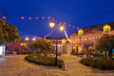 Un chef pâtissier en toque décore une tarte meringuée à l'extérieur, près d'un batteur sur socle.