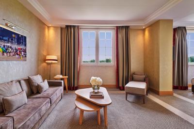 Chambre d'hôtel avec un grand lit double, des oreillers rouges, un éclairage doux et une décoration murale colorée.