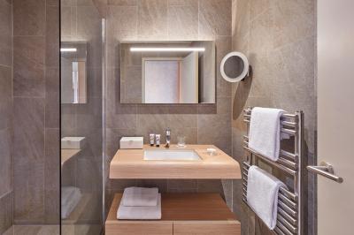 Chambre d'hôtel avec un grand lit double, des oreillers rouges, un éclairage doux et une décoration murale colorée.