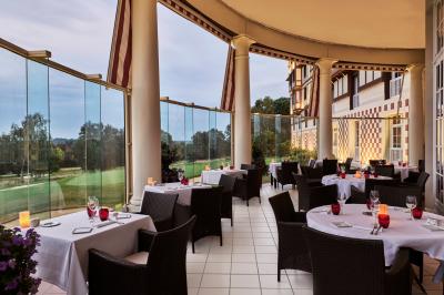 Chambre d'hôtel avec un grand lit double, des oreillers rouges, un éclairage doux et une décoration murale colorée.