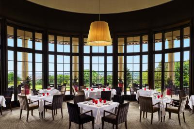 Chambre d'hôtel avec un grand lit double, des oreillers rouges, un éclairage doux et une décoration murale colorée.