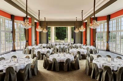 Chambre d'hôtel avec un grand lit double, des oreillers rouges, un éclairage doux et une décoration murale colorée.
