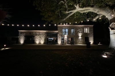 Miniature Location salle Monteux (Vaucluse) - Mas Adamon #3 Cour extérieure éclairée de nuit avec des guirlandes lumineuses suspendues à un grand arbre et des lampes au sol.