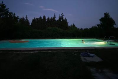 Maison avec terrasse entourée de végétation, située dans un jardin avec allée en gravier et ciel dégagé en arrière-plan.
