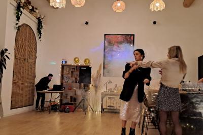 Maison avec terrasse entourée de végétation, située dans un jardin avec allée en gravier et ciel dégagé en arrière-plan.