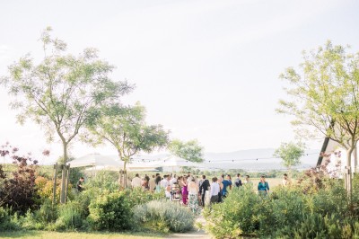 Miniature Location salle Meyrargues (Bouches-du-Rhône) - Château de Vauclaire #10 Groupe de personnes assises et discutant dans un jardin ensoleillé avec des parasols blancs.