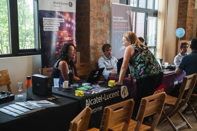 Miniature Location salle Meyrargues (Bouches-du-Rhône) - Château de Vauclaire #5 Groupe de personnes assises et discutant dans un jardin ensoleillé avec des parasols blancs.