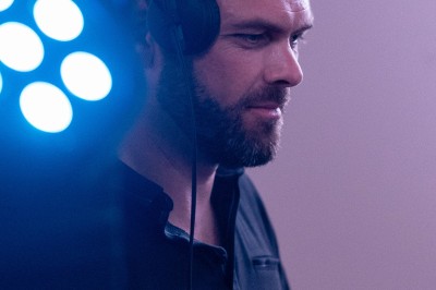 Miniature DJ partenaire Groupe de personnes assises et discutant dans un jardin ensoleillé avec des parasols blancs.