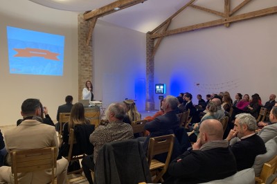 Miniature Matériel de vidéoprojection & son haut de gamme Groupe de personnes assises et discutant dans un jardin ensoleillé avec des parasols blancs.