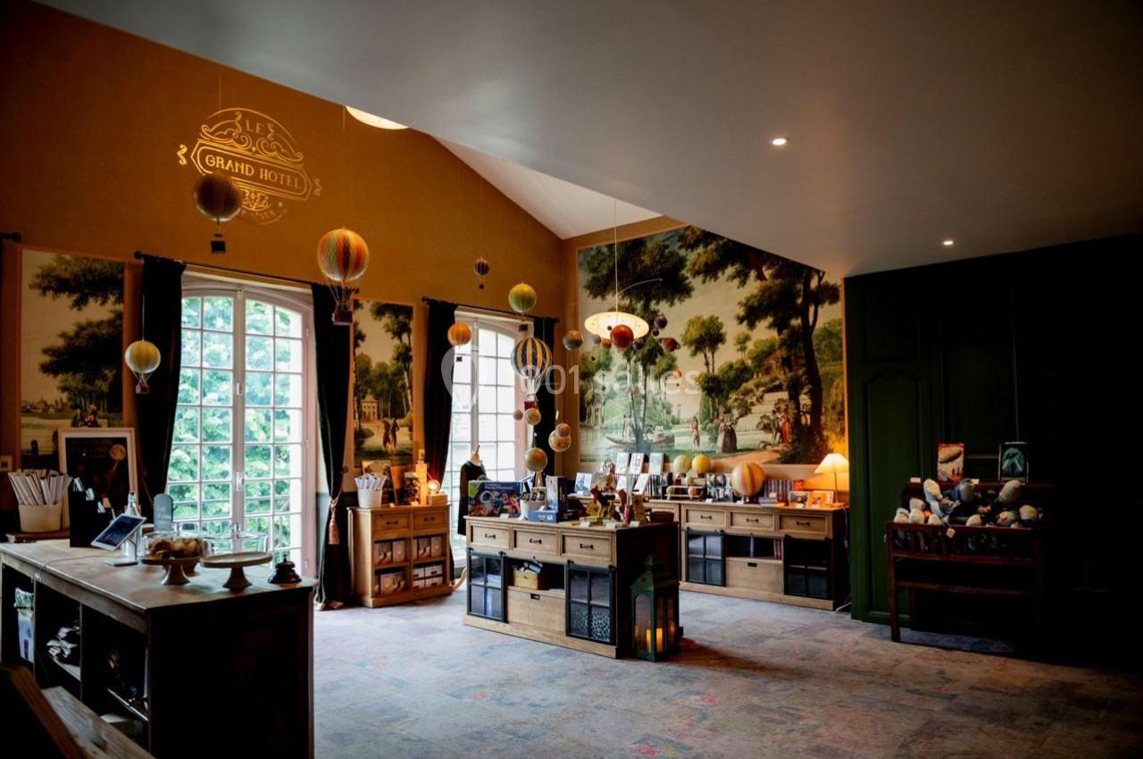 Boutique décorée avec des meubles en bois, des objets artisanaux et des suspensions colorées dans une ambiance chaleureuse.