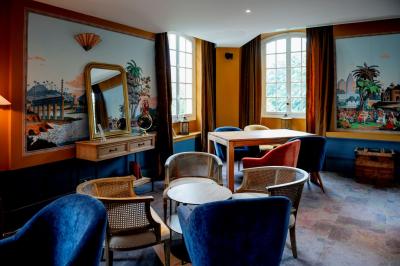 Vue d'un jardin verdoyant avec des arbres, des buissons et une grande cage métallique décorative au centre.