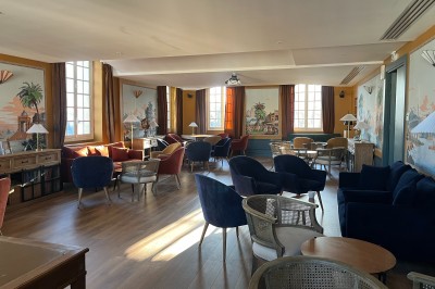 Vue d'un jardin verdoyant avec des arbres, des buissons et une grande cage métallique décorative au centre.