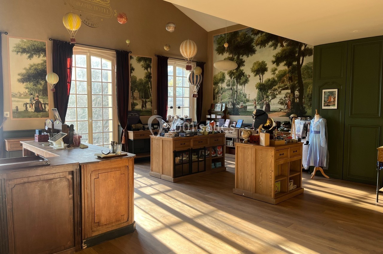 Intérieur d'une boutique lumineuse avec comptoirs en bois, étagères de produits et décorations murales champêtres.