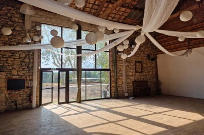 Miniature Location salle Peyrolles-en-Provence (Bouches-du-Rhône) - Presqu'ile de Real Plantain #14 Chambre avec lit recouvert d'un couvre-lit à motif léopard, fauteuil assorti et miroir encadré sur un mur clair.