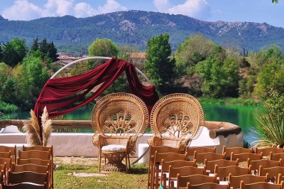 Miniature Location salle Peyrolles-en-Provence (Bouches-du-Rhône) - Presqu'ile de Real Plantain #30 Chambre avec lit recouvert d'un couvre-lit à motif léopard, fauteuil assorti et miroir encadré sur un mur clair.