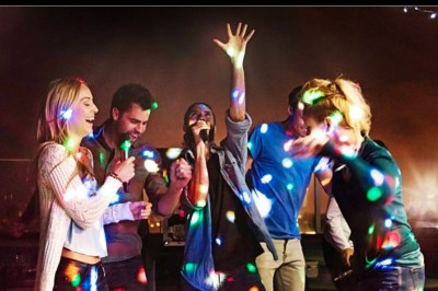 Femme avec casque audio devant une table de mixage dans un espace intérieur décoré pour un événement.