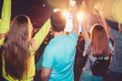 Femme avec casque audio devant une table de mixage dans un espace intérieur décoré pour un événement.