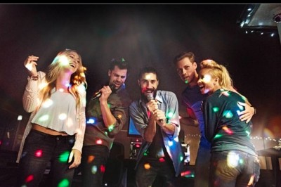 Femme avec casque audio devant une table de mixage dans un espace intérieur décoré pour un événement.