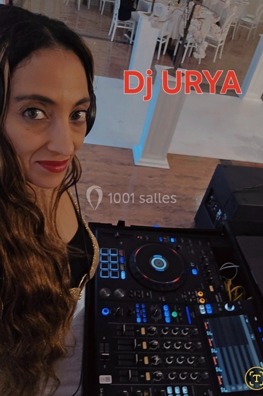 Femme avec casque audio devant une table de mixage dans un espace intérieur décoré pour un événement.