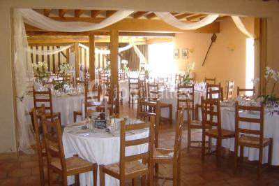 Chambre avec un lit double, une lampe de chevet allumée, un lit superposé en bois et un mur peint en rose pâle.