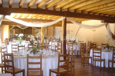 Chambre avec un lit double, une lampe de chevet allumée, un lit superposé en bois et un mur peint en rose pâle.