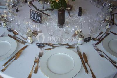 Chambre avec un lit double, une lampe de chevet allumée, un lit superposé en bois et un mur peint en rose pâle.