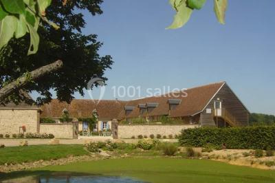 Chambre avec un lit double, une lampe de chevet allumée, un lit superposé en bois et un mur peint en rose pâle.