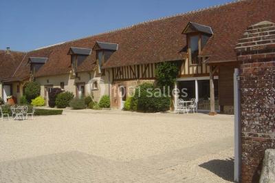 Chambre avec un lit double, une lampe de chevet allumée, un lit superposé en bois et un mur peint en rose pâle.