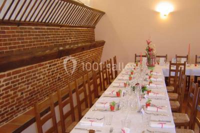 Chambre avec un lit double, une lampe de chevet allumée, un lit superposé en bois et un mur peint en rose pâle.