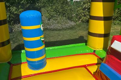 Trois valises vintage empilées, en cuir et tissu, posées sur une surface en extérieur avec de l'herbe en arrière-plan.