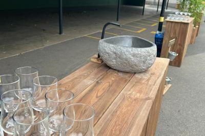 Trois valises vintage empilées, en cuir et tissu, posées sur une surface en extérieur avec de l'herbe en arrière-plan.