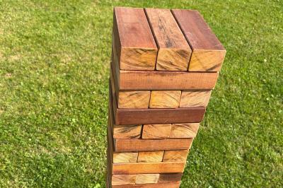 Trois valises vintage empilées, en cuir et tissu, posées sur une surface en extérieur avec de l'herbe en arrière-plan.