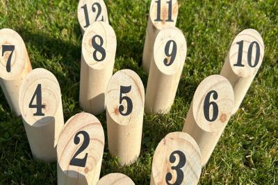 Trois valises vintage empilées, en cuir et tissu, posées sur une surface en extérieur avec de l'herbe en arrière-plan.